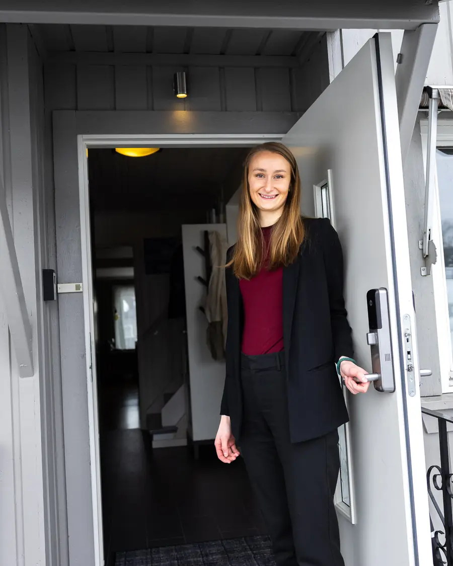 Lotte Gulbrandsen står smilende i døra til sin første bolig.