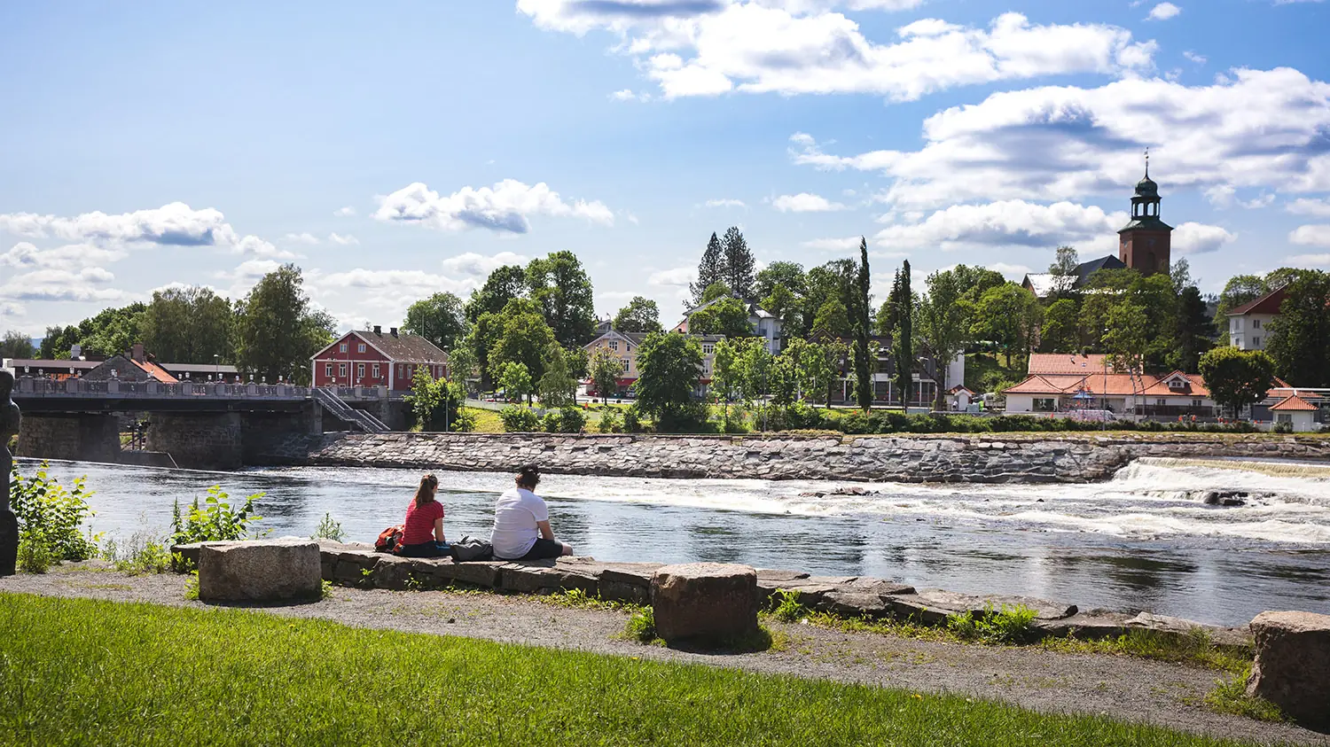 Kongsberg sentrum sett fra elvebredden, med fossen, brua og Kongsberg kirke.