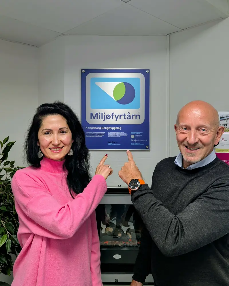 To ansatte i KBBL viser fram Miljøfyrtårn-diplomet på kontoret.